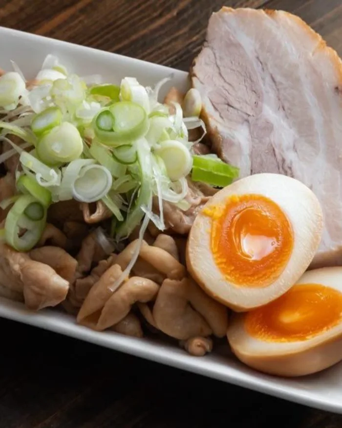 おつまみの盛り合わせ。ホルモンとチャーシューと味玉と白ねぎ
